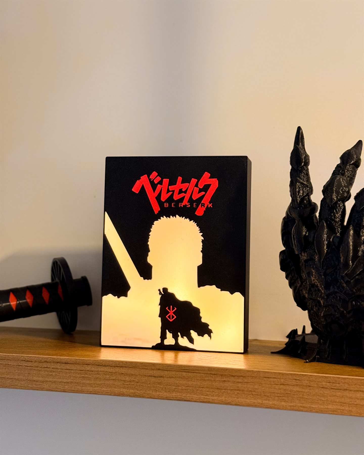 Luminária Black Swordsman acesa em estante de quarto ao lado de espada decorativa e escultura de dragão